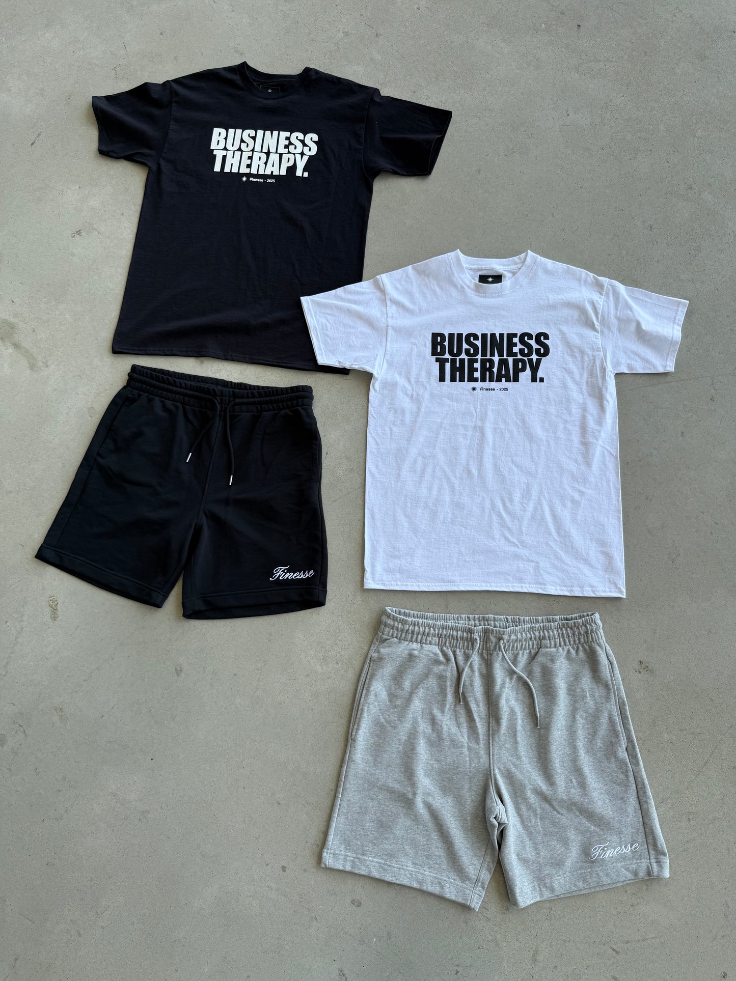 Packshot au sol avec Cotton Shorts noir et gris, associés aux T-shirts Business Therapy noir et blanc