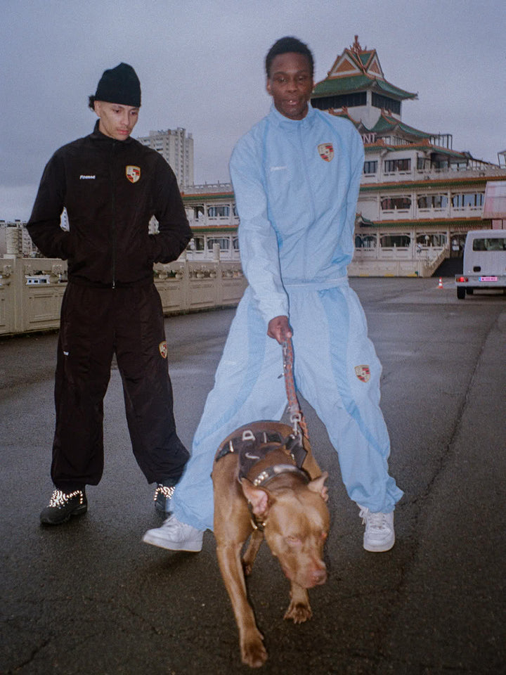 Model wearing the 911 tracksuit in black, zip jacket and jogger - Finesse lookbook
