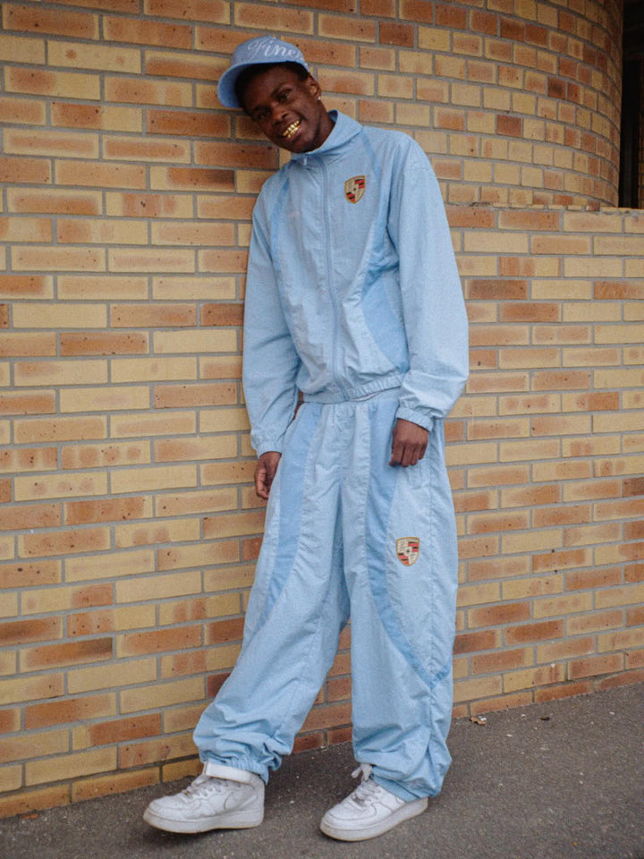 Model wearing the 911 tracksuit in blue, zip jacket and jogger - Finesse lookbook