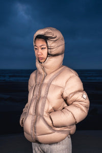 Zoom sur femme mains dans les poches portant la Alive Puffer Jacket beige