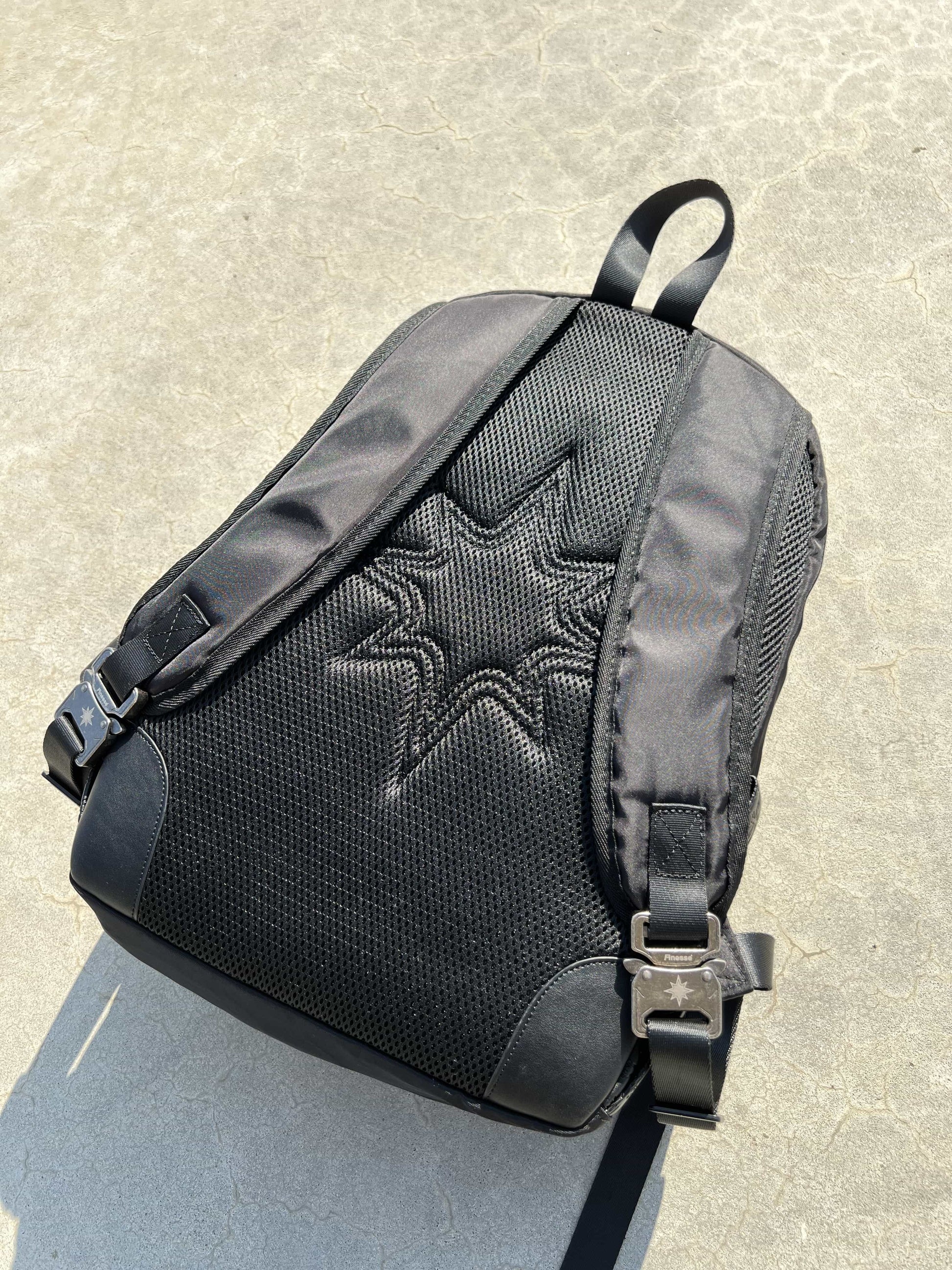 Finesse Black Vanta Backpack présenté de dos au sol, angle diagonal