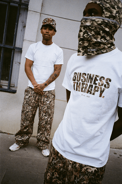 Deux hommes en Business Therapy T-shirt, l’un cagoulé, l’autre avec la Finesse "SIGN" Cap-CAMO, portant un cargo pant.