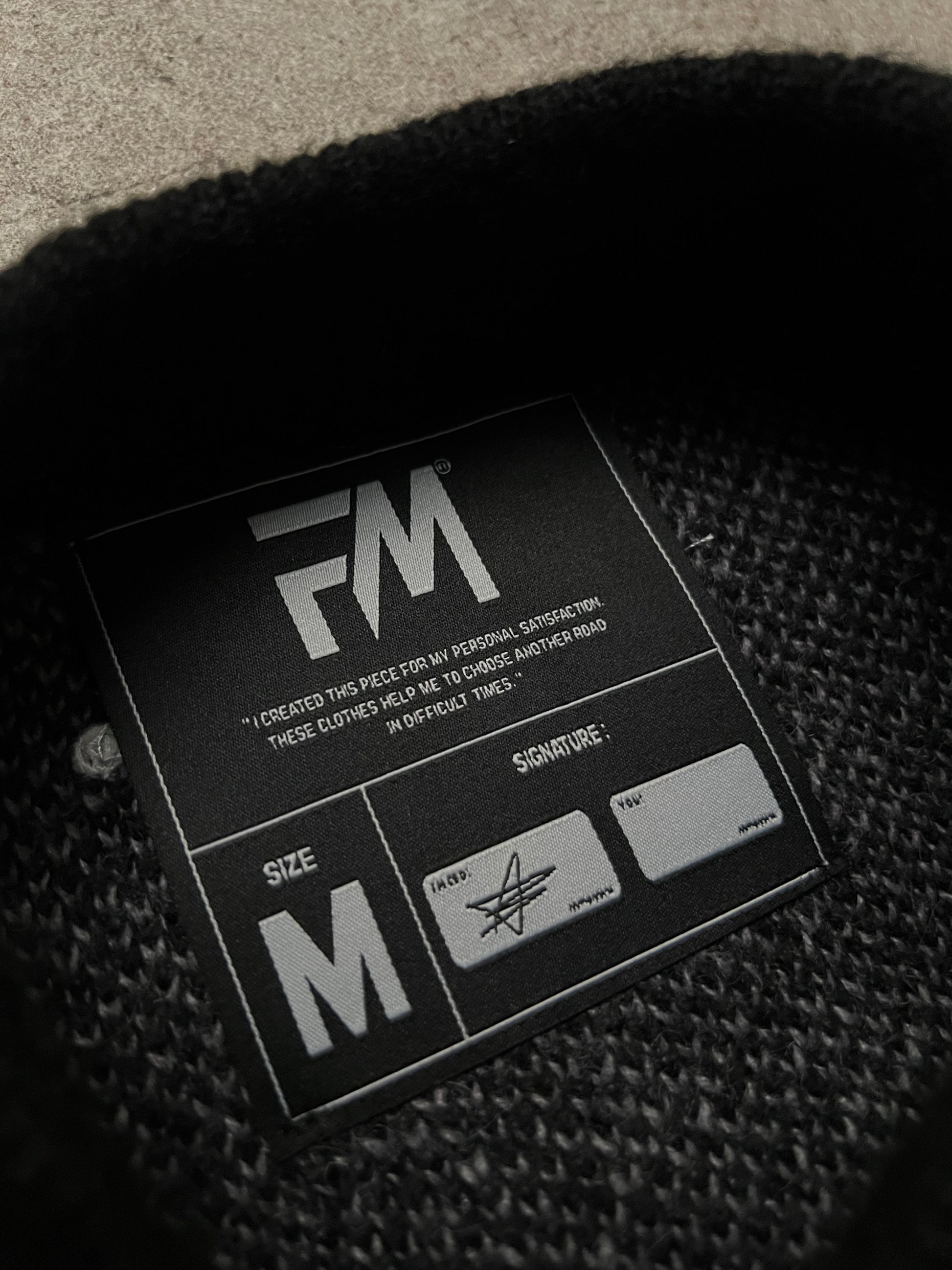 Étiquette avec indication de taille et une phrase inspirationnelle imprimée.