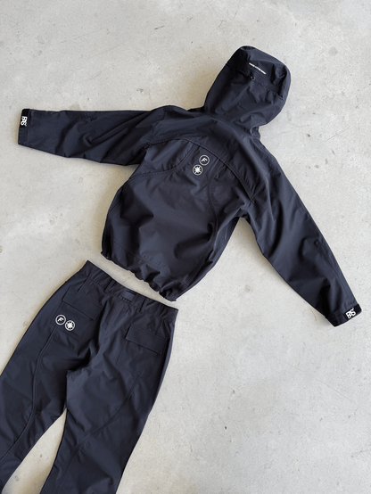 FAS Hardshell et Hardpant noirs posés au sol, pantalon retourné