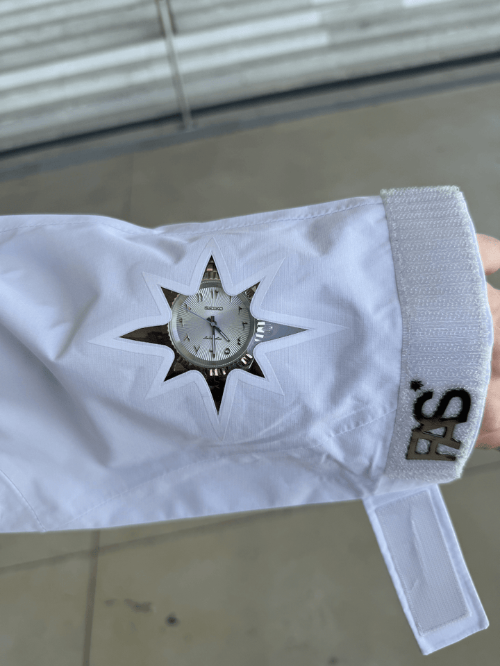 Zoom sur une manche de la Hardshell blanche FAS, détails visibles.