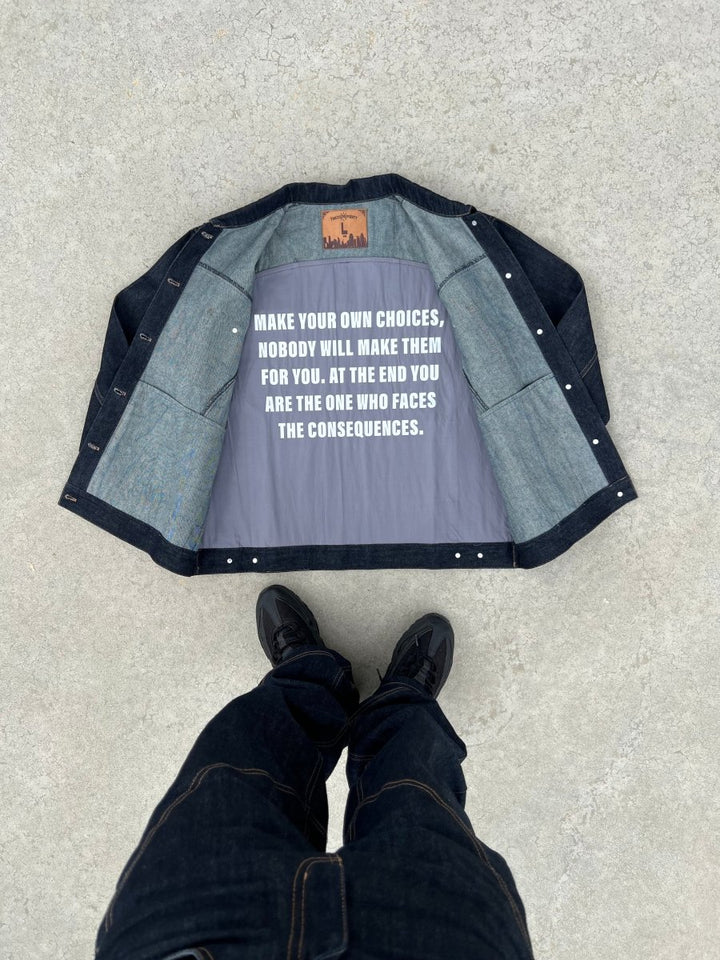 Zoom sur l’intérieur de la veste Finesse ADV Denim set  posée au sol, avec inscription imprimée au dos.