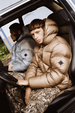 Vue subjective d’un mannequin portant la Finesse* Alive Puffer Jacket Light Bronze au volant d’une voiture.