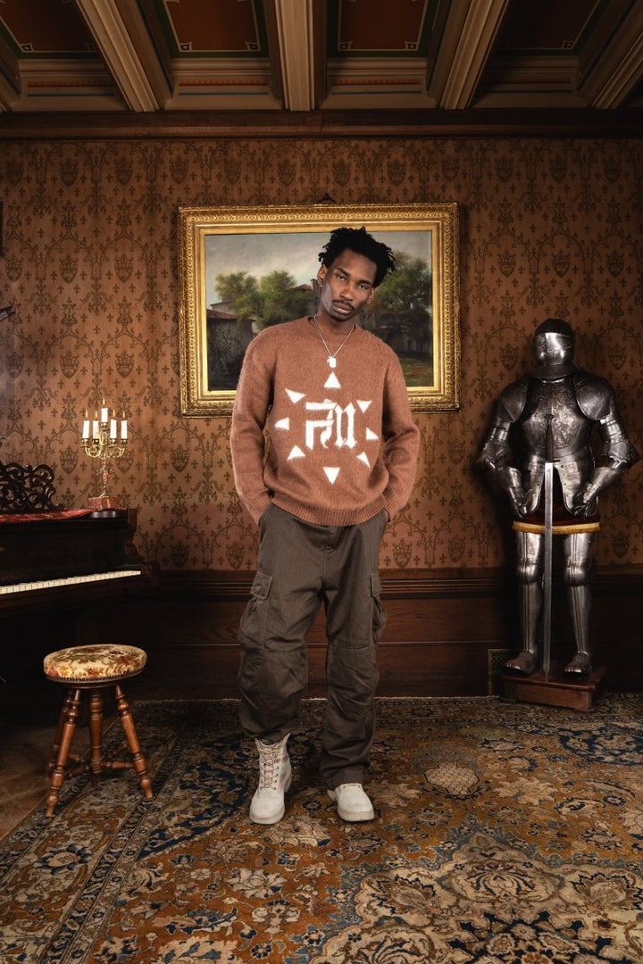 Homme dans un château portant le Finesse Brandenburg Mohair et la chaîne Finesse Keychain, posé devant le décor ancien.