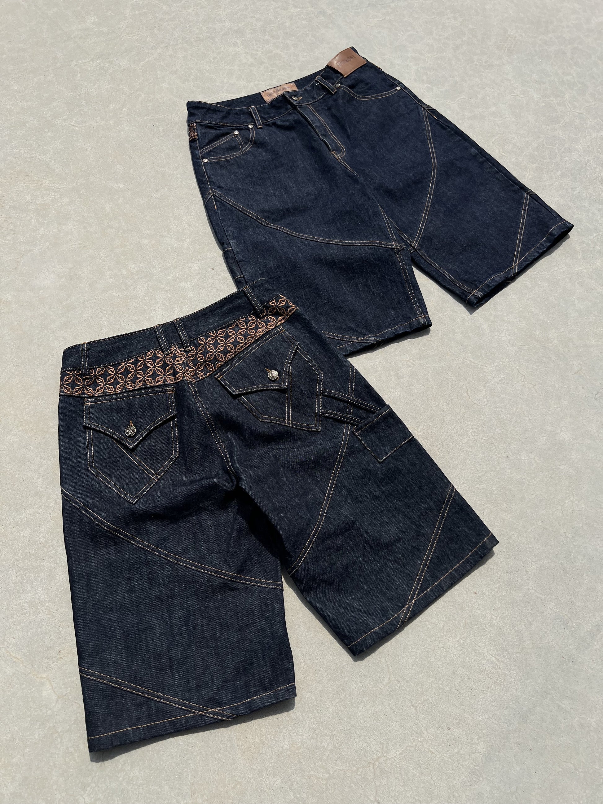 Deux Finesse Denim Shorts présentés à plat sur sol en béton, vue avant et arrière.