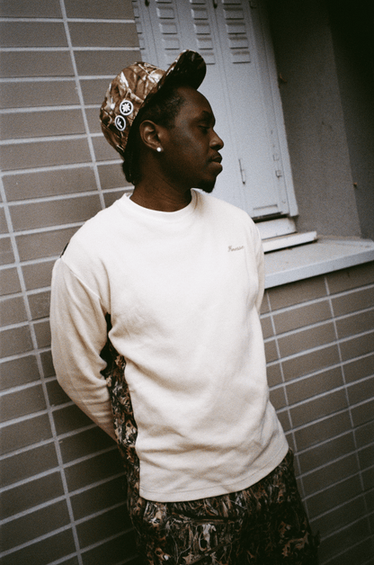 Zoom sur le rappeur 15 KAINZ en Finesse Military Top-Camo et "SIGN" Cap-CAMO, look street concentré.