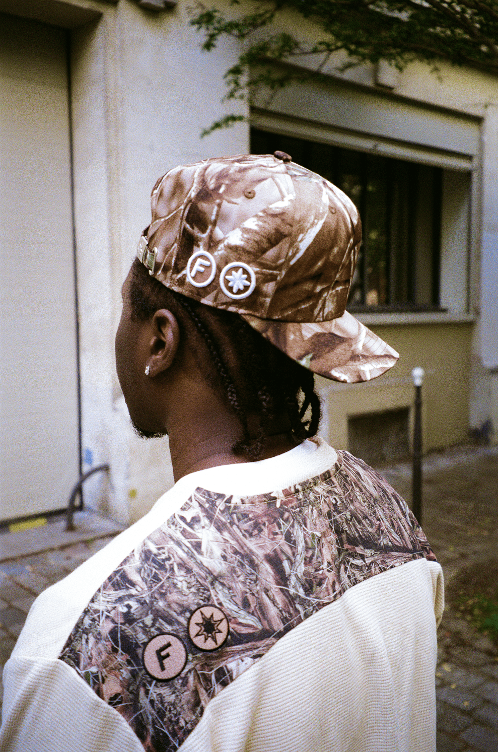 Zoom sur la tête du rappeur 15 KAINZ de dos, portant la Finesse "SIGN" Cap-CAMO à l’envers.