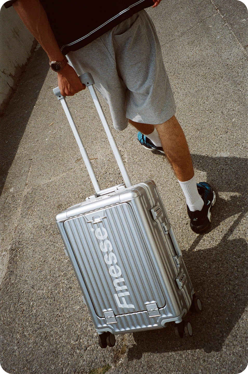 Photo argentique d’un homme tirant la valise Finesse Go Away Suitcase dans la rue