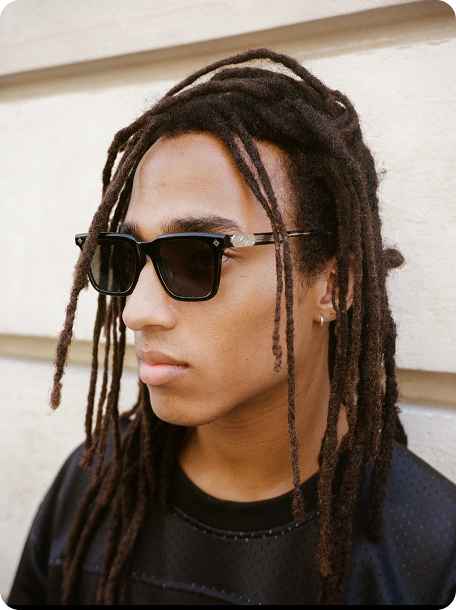 Homme avec des locks portant les lunettes Finesse Sunglasses Series 01, regard vers la droite