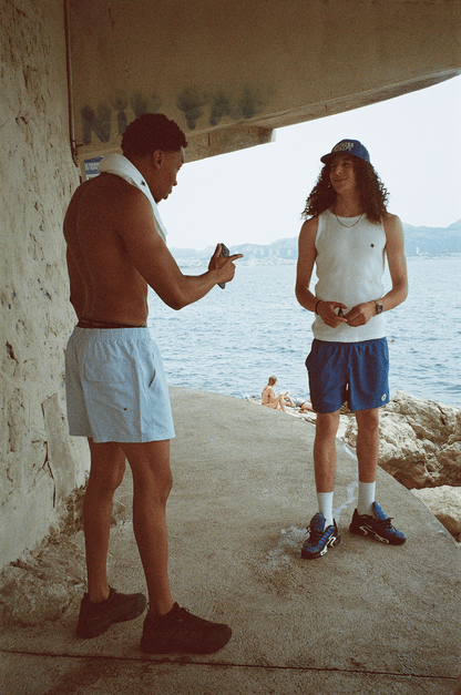Deux hommes rient sous un rocher des calanques, en Swim Shorts et Tank Top