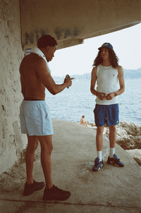 Deux hommes rient sous un rocher des calanques, en Swim Shorts et Tank Top