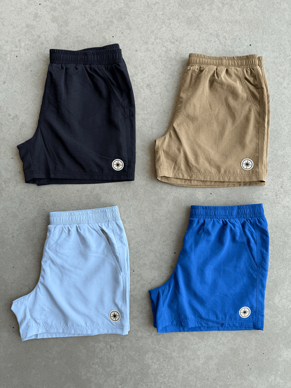 Quatre Finesse Swim Shorts posés ensemble au sol en packshot.