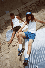 Deux hommes sur serviette Finesse en argentique, en Tank Top et casquettes Business Therapy.