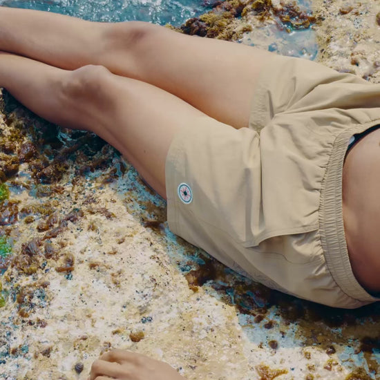 Vidéo d’une femme en Swim Shorts Big Brown, vague révélant le monogramme