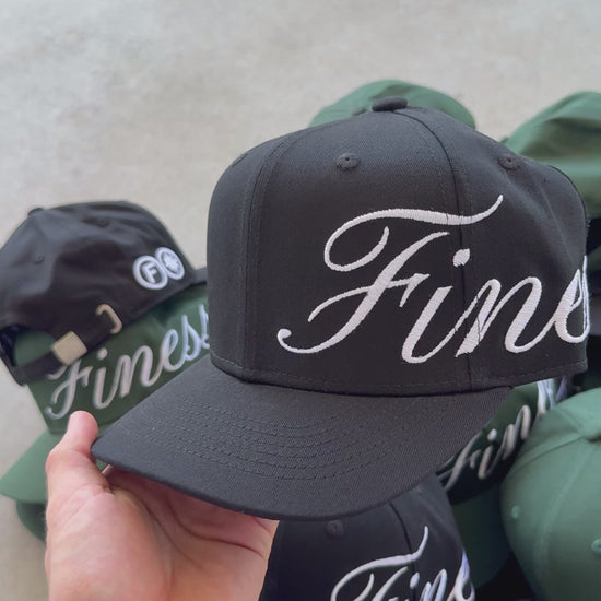 Vidéo détaillant la casquette Finesse Sign Cap noire, arrière-plan vert et noir