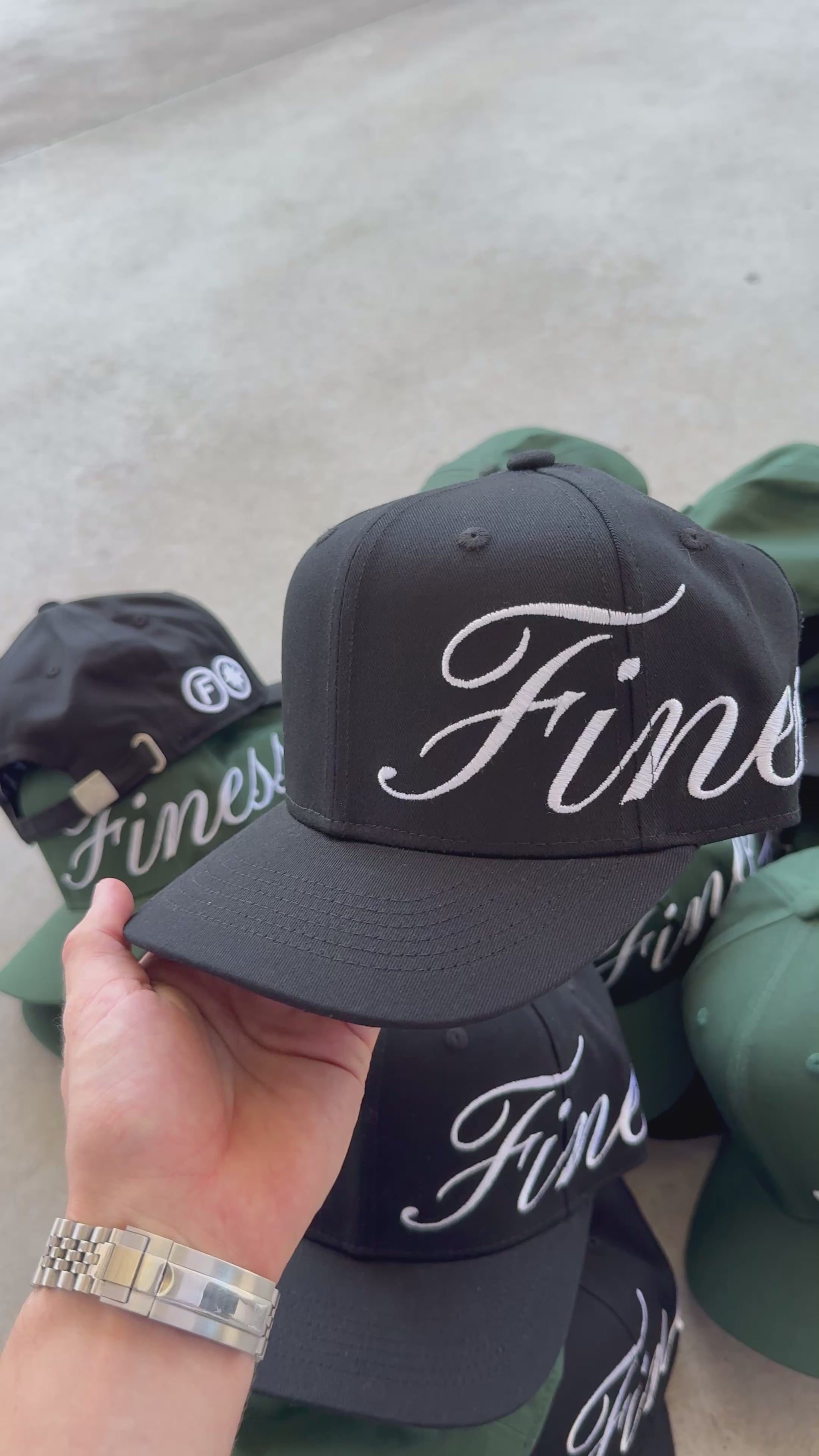 Vidéo détaillant la casquette Finesse Sign Cap noire, arrière-plan vert et noir